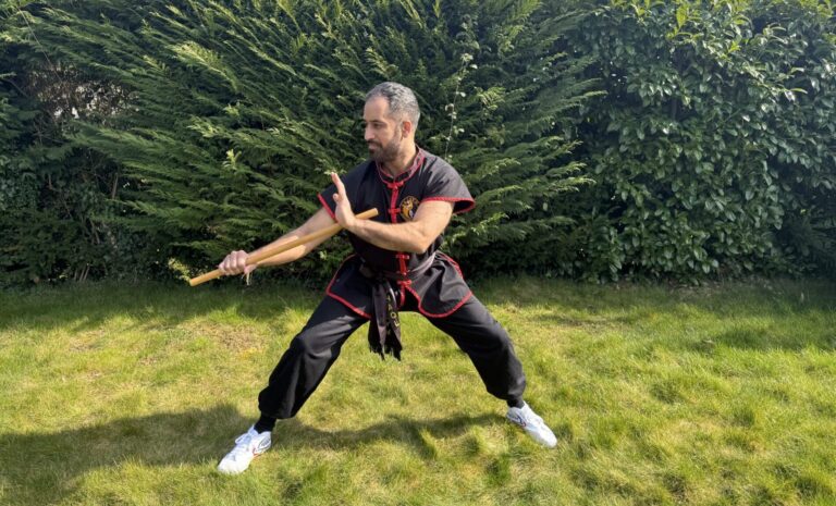 Sifu Kam performing traditional Shaolin Kung Fu form with focus and balance